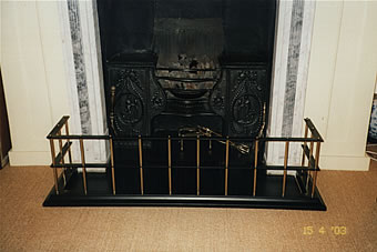 A fender guard with a Burnished Steel base, central & top dividers also in burnished steel with round 5/8″ uprights and small round finials in dulled brass. Low Level Fender in Burnished Steel with Solid Brass collars.